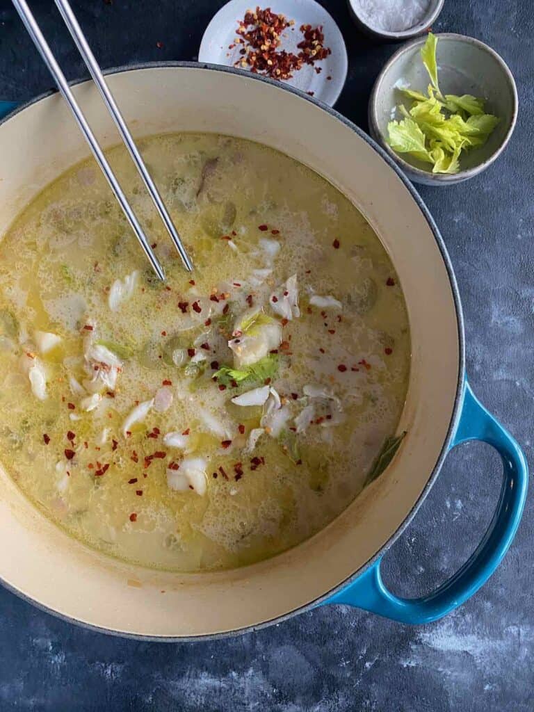 this shows a big pot of crab, cod and chickpea chowder