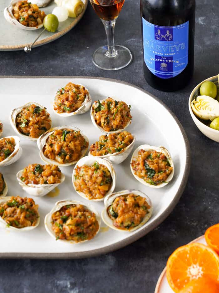 Stuffed clams on a table with cream sherry.